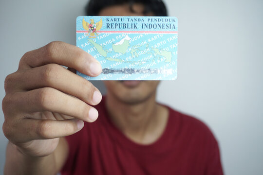 Jakarta, Indonesia - June 4, 2022: A person shows and holds two Indonesian identity cards (KTP). Selective focus