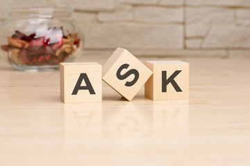 ASK - acronym from wooden blocks with letters, top view on grey background