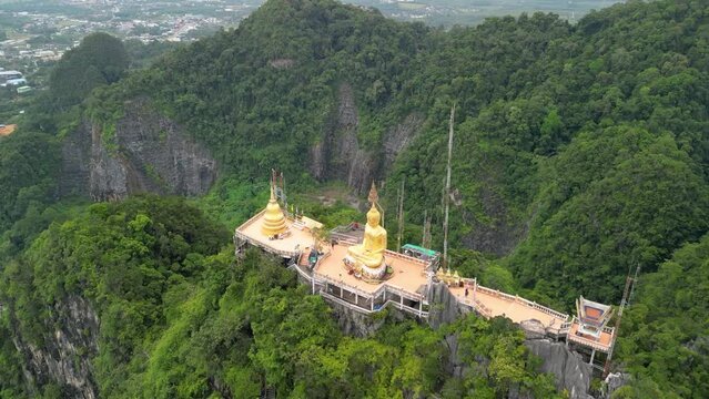 Drone shot of tiger cave temple, Krabi Thailand. Aerial view of a Buddhist temple on a mountain. Golden Buddha statue.