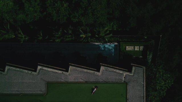 Woman practice yoga on roof, drone fly up,top view