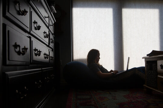 Silhouette of boy on a computer