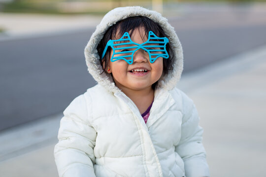 Girl laughing wearing louvered star shaped glasses