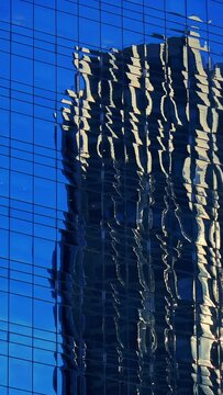 Skyscraper glass façade, mirroring distorted architecture, detail, sky and sun reflection, New York City, timelapse vertical video