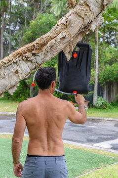 Hispanic Man Using Camp Shower On A Campground On Sunshine Coast