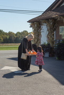 Girl with grandma in parking lot at a pumpkin patch