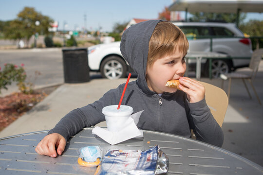 Young boy eating a burger at a drive-in
