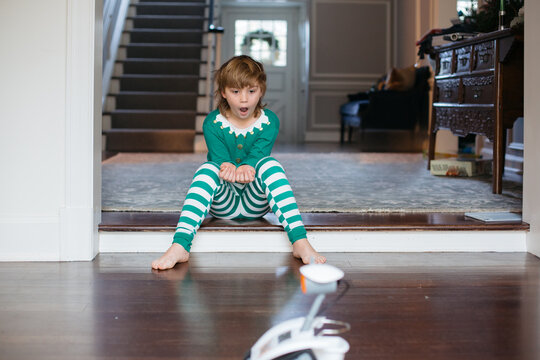 Boy in elf pajamas playing with robot toy