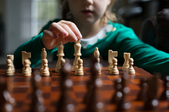 Boy's chin view as his left hand playing chess