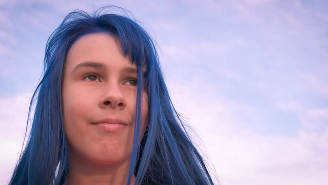 Beautiful dyed hair style girl by ocean. A beautiful teen enjoy the freedom and wind in her dyed hair on the shore.