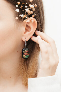 woman wearing floral epoxy earrings   