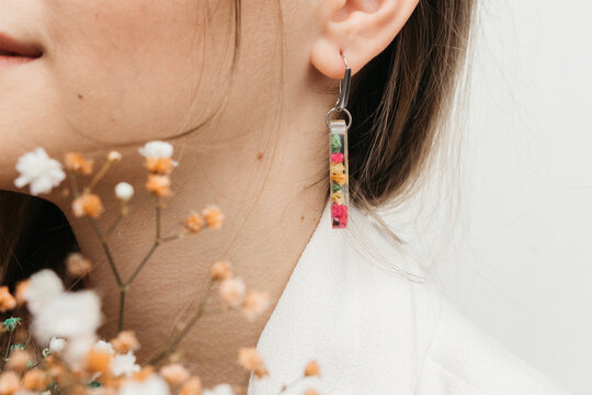 woman wearing floral epoxy earrings   