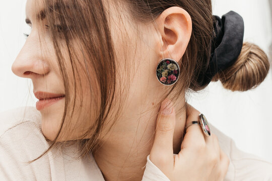 woman wearing floral epoxy earrings   