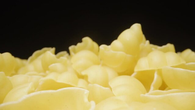 The camera pulls back and I slowly pour the gnocchetti pasta out of my hand. Dolly slider extreme close-up.