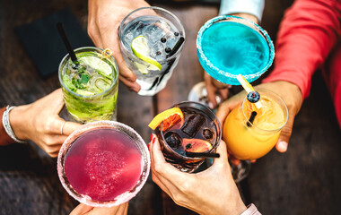 Top view of people hands toasting fancy drinks - Young friends having fun drinking cocktails at...
