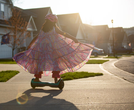 Girl in long flowing dress riding away on a hoverboard