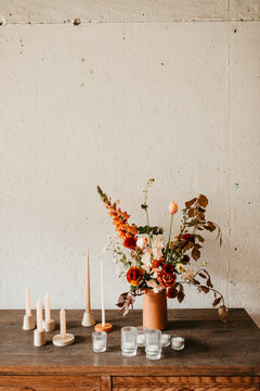 Orange flowers and candles on a rustic table indoors