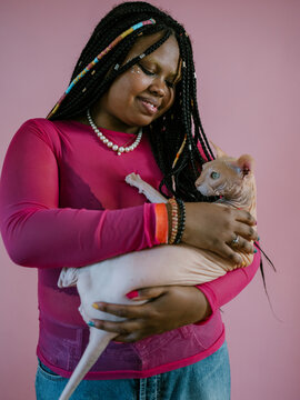 Plus size braided girl holding hairless cat
