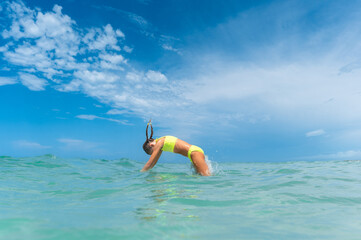 Girl diving into aqua blue water