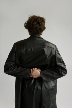 Unrecognisable  guy's back in a leather coat with folded hands over it