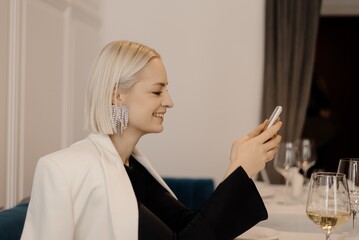 Smiling woman using smartphone in restaurant
