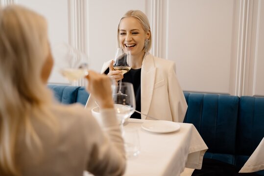 Happy girlfriends proposing toast in restaurant
