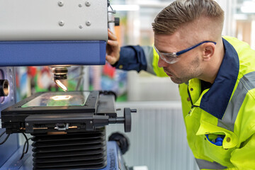 Engineer sitting in robot fabrication room use measuring microscope machine check microchip