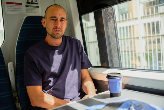Man on train with take away coffee 