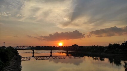 Fototapeta na wymiar Natural beautiful silhouettes scenery sunrise background of bridge on the river during sunrise