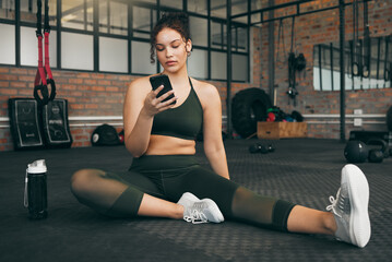 Fitness, phone and woman at gym for a workout, training and body wellness with a mobile app. Young...
