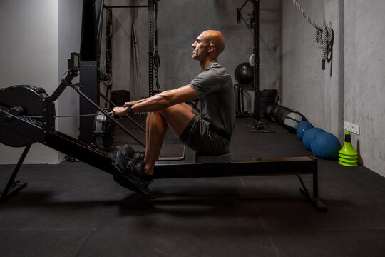 Sportsman exercising on rowing machine