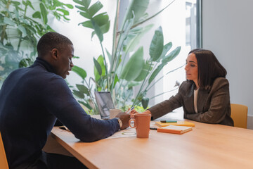 Diverse colleagues correcting report during meeting