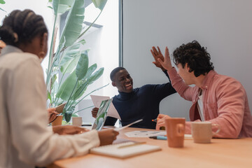 Diverse colleagues giving high five