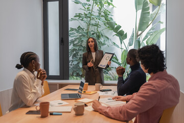 Businesswoman discussing financial report with team