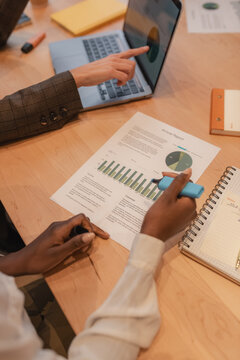 Black businesswoman marking data on paper