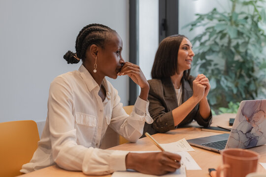 Diverse businesswomen sitting at table during meeting