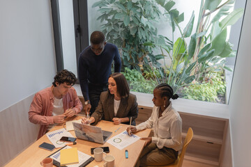 Diverse colleagues analyzing data on laptop