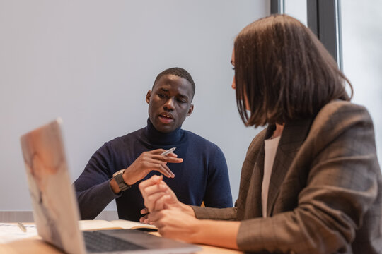 Multiracial coworkers analyzing data on laptop