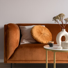 Ocher colored sofa and decorated coffee table, close-up