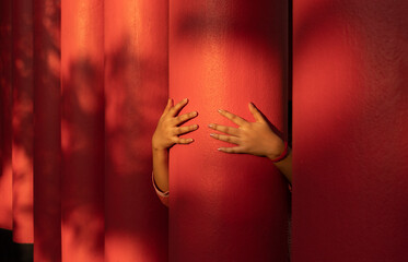 A girl grips and holds a red colored pillar at outdoors