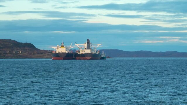 Bunkering of large tankers. Vessels close to shore side by side with each other. View from rear