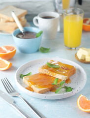 Sandwiches with marmalade, orange juice and coffee ready for breakfast