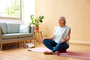 Senior woman meditating at home