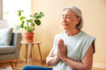 Senior woman meditating at home