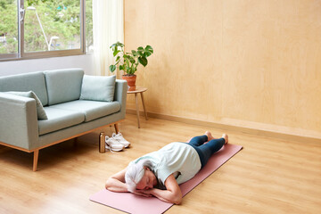 Senior woman resting on yoga mat