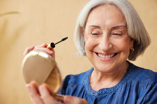 Cheerful female pensioner looking in mirror