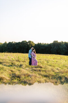 Romantic couple hugging in a field. they are expecting a child.