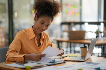 African American businesswoman working in her office accountant concept finance analysis business report graph chart financial chart corporate economy, banking, market research.