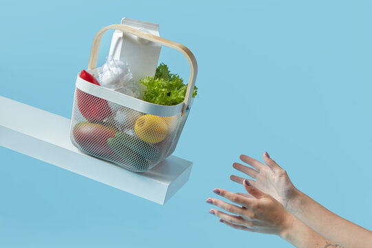 Groceries in plastic basket caught by woman.