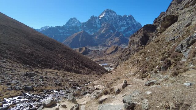 Cho La Pass, Nepal: Point of view of an hiker walking down the Chola pass toward Dragnag, or Thragnak, in the Gokyo valley coming from the Everest base camp in the Himalayas in Nepal. 