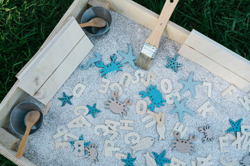 Set of educational toys in sensory box on lawn